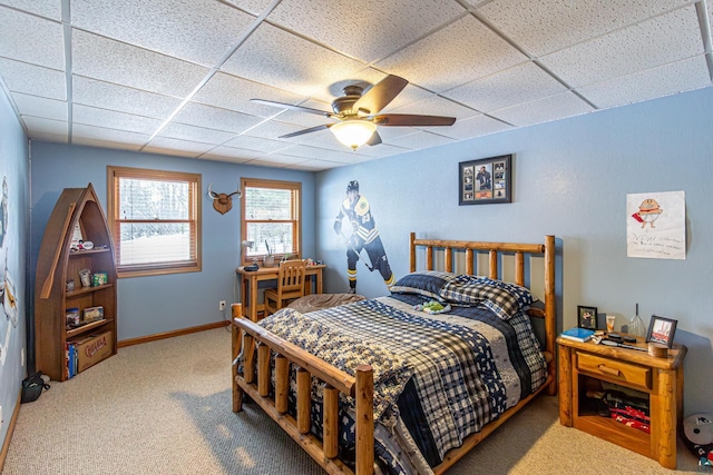 bedroom with carpet floors, ceiling fan, baseboards, and a paneled ceiling