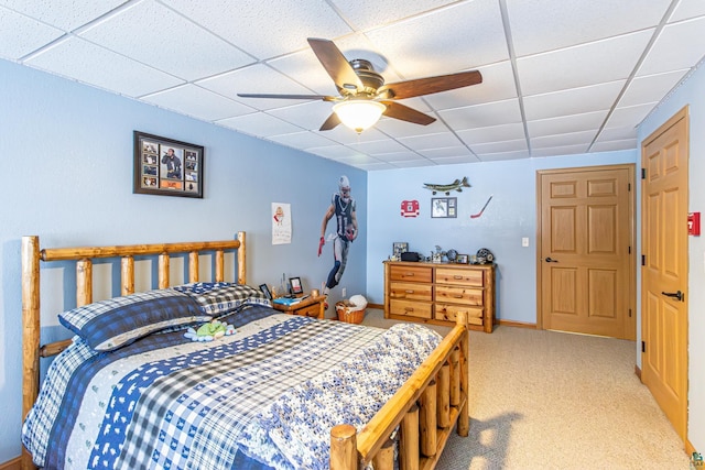 bedroom featuring a paneled ceiling, light colored carpet, ceiling fan, and baseboards