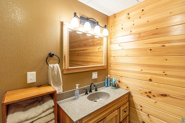 bathroom with a textured wall and vanity