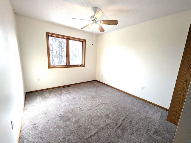 spare room with a ceiling fan, carpet, a textured ceiling, and baseboards