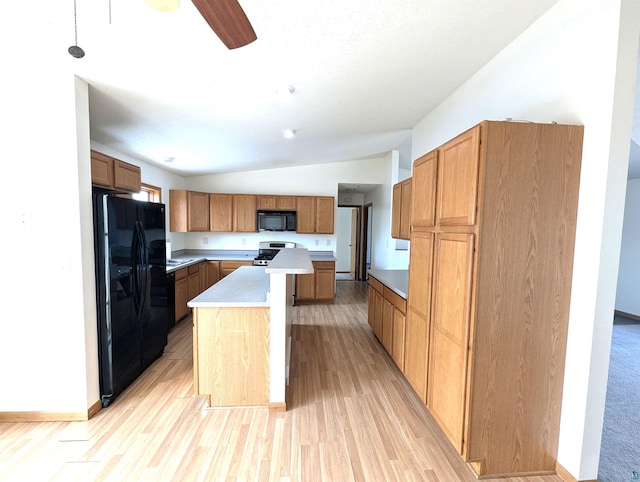 kitchen featuring lofted ceiling, light wood-style flooring, light countertops, a center island, and black appliances