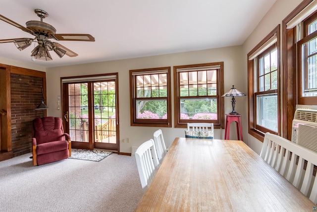 unfurnished dining area featuring a ceiling fan, carpet, plenty of natural light, and baseboards