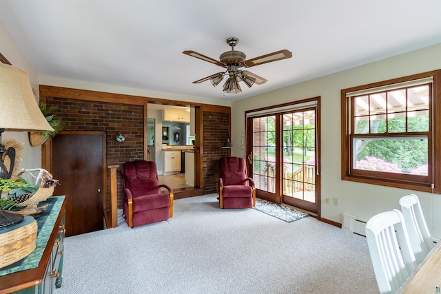 sitting room featuring a baseboard radiator, a ceiling fan, and carpet flooring