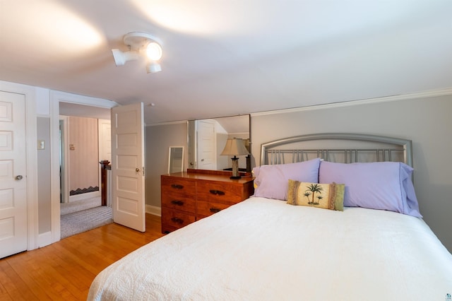 bedroom with light wood-type flooring, ceiling fan, and baseboards