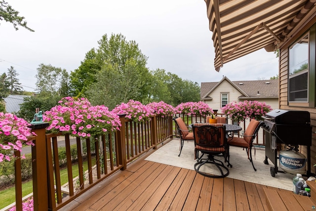 wooden deck with outdoor dining area and a grill