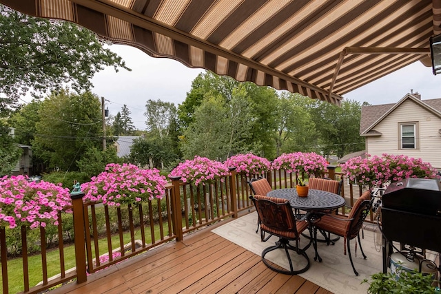 wooden terrace with outdoor dining area and a grill