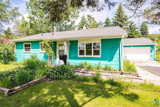 ranch-style house with a shingled roof, an outdoor structure, concrete driveway, and a front yard