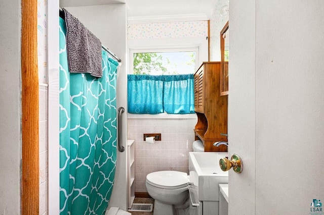 full bath featuring tile walls, curtained shower, visible vents, toilet, and ornamental molding