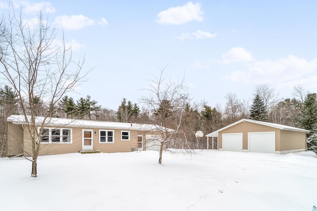 view of front of home with a garage and an outbuilding