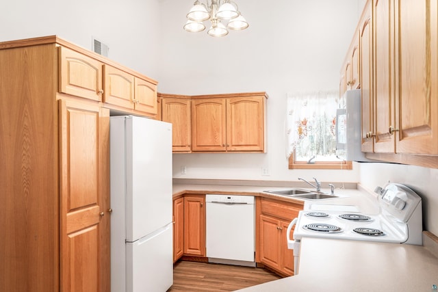 kitchen with light countertops, visible vents, a sink, light wood-type flooring, and white appliances