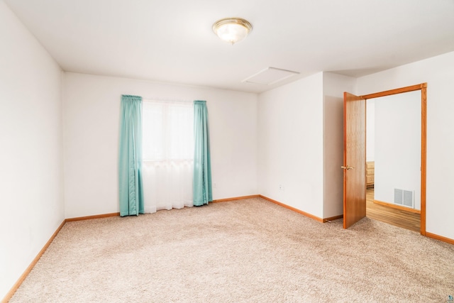 empty room featuring baseboards, carpet flooring, visible vents, and attic access