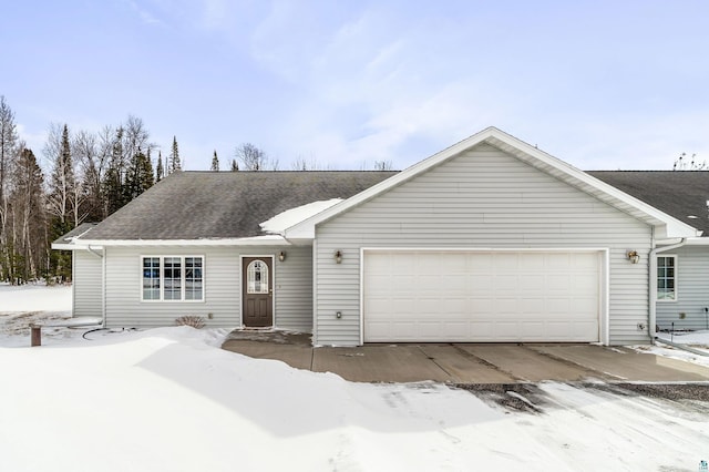 ranch-style house featuring a garage and roof with shingles