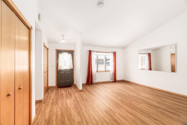 entryway with light wood-style flooring, baseboards, and vaulted ceiling