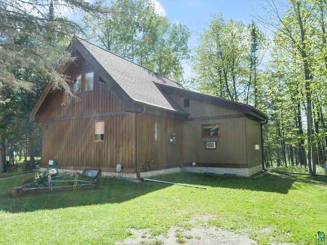 view of property exterior featuring roof with shingles and a yard