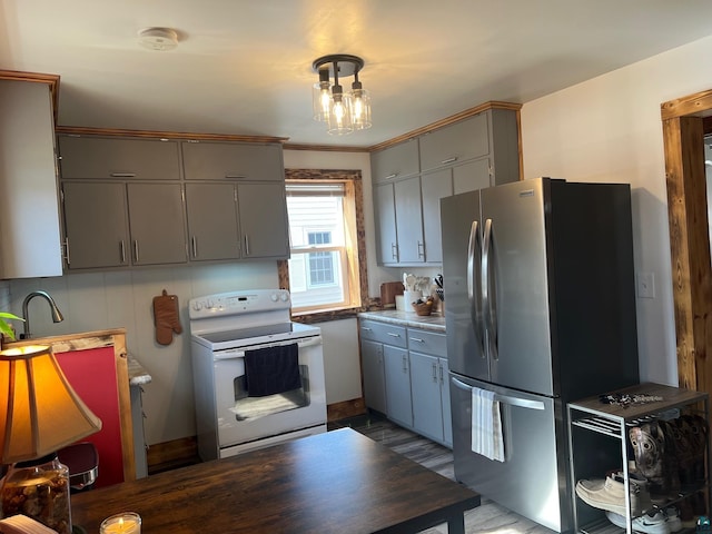 kitchen with white range with electric cooktop, gray cabinets, and freestanding refrigerator