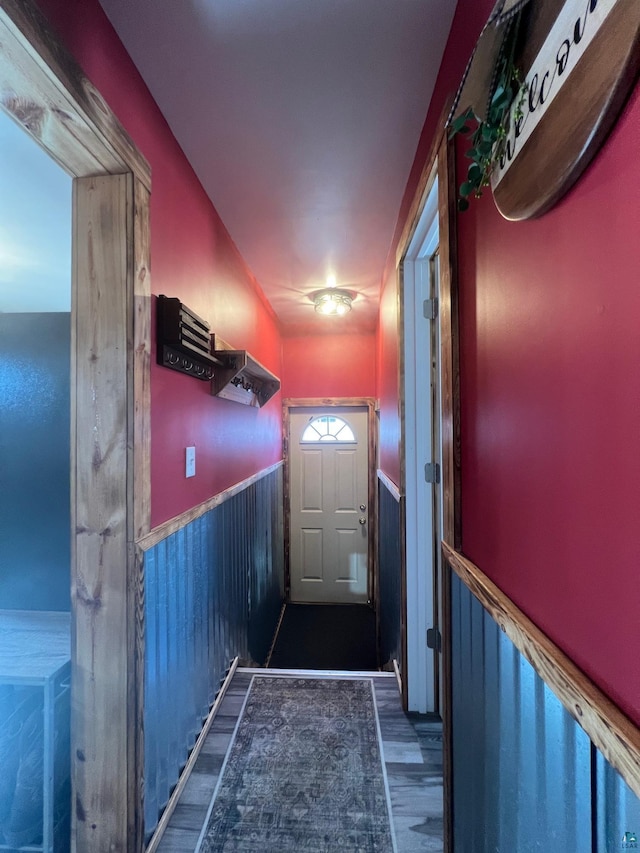 entryway with dark wood finished floors and wainscoting