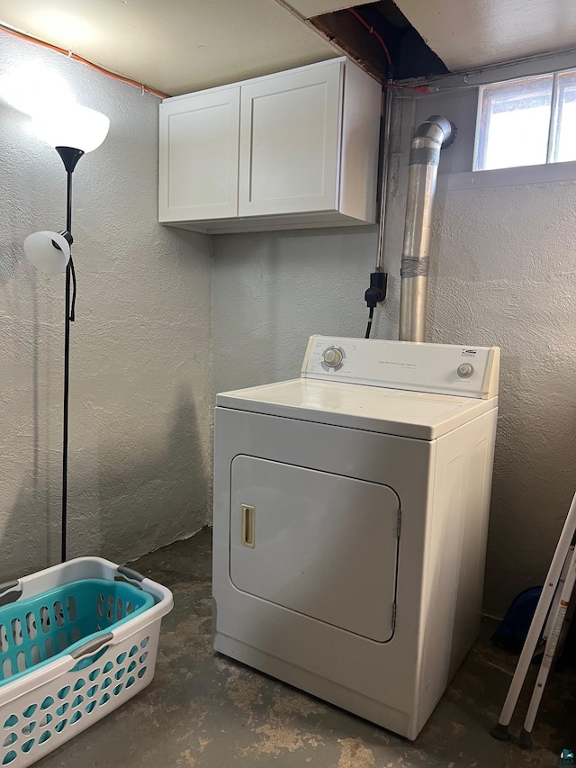 laundry area featuring washer / clothes dryer, cabinet space, and a textured wall