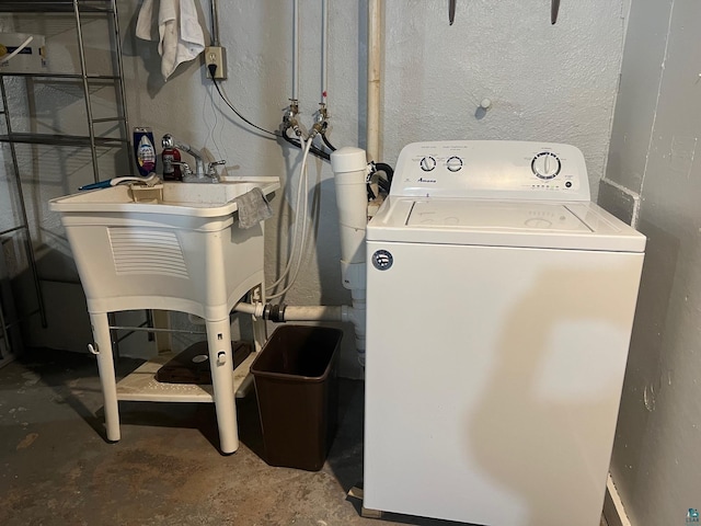 clothes washing area with laundry area, washer / dryer, and a textured wall