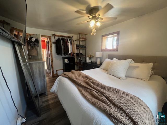 bedroom with dark wood-style floors and a ceiling fan