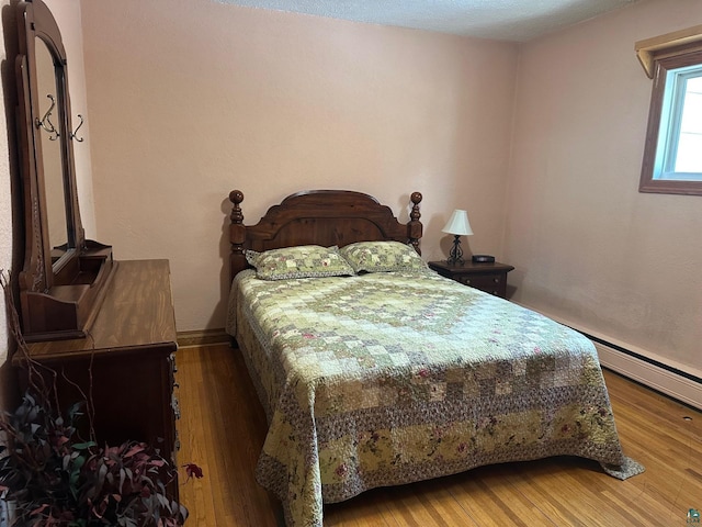 bedroom featuring baseboards and wood finished floors