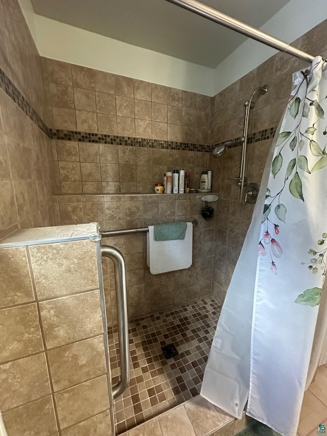 full bath with a shower stall and tile patterned flooring