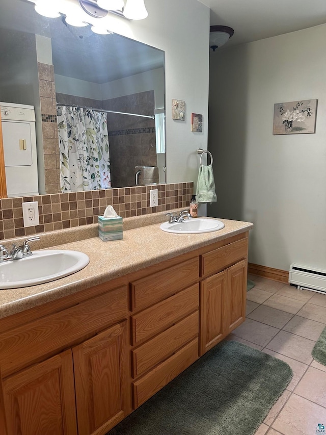 bathroom with a sink, a baseboard heating unit, washer / clothes dryer, and tile patterned floors