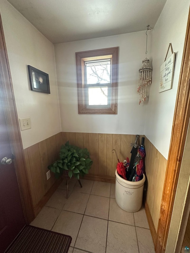 bathroom featuring tile patterned flooring, wainscoting, and wood walls