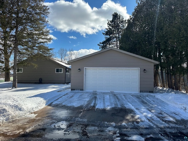 snow covered garage featuring a detached garage