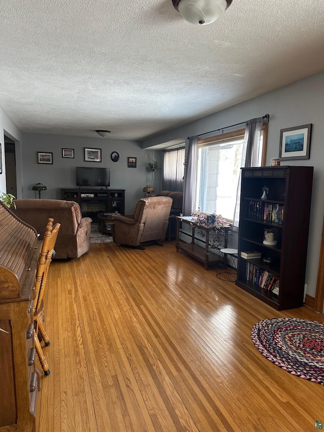 living area featuring light wood-style flooring and a textured ceiling