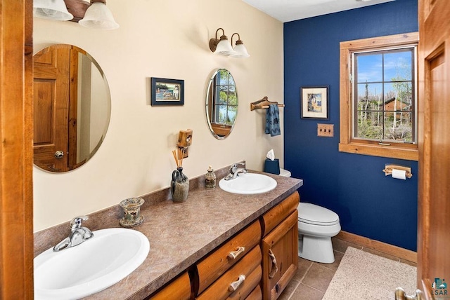 full bathroom featuring a sink, toilet, double vanity, and tile patterned flooring