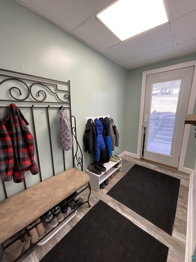 mudroom with wood finished floors, a paneled ceiling, and baseboards