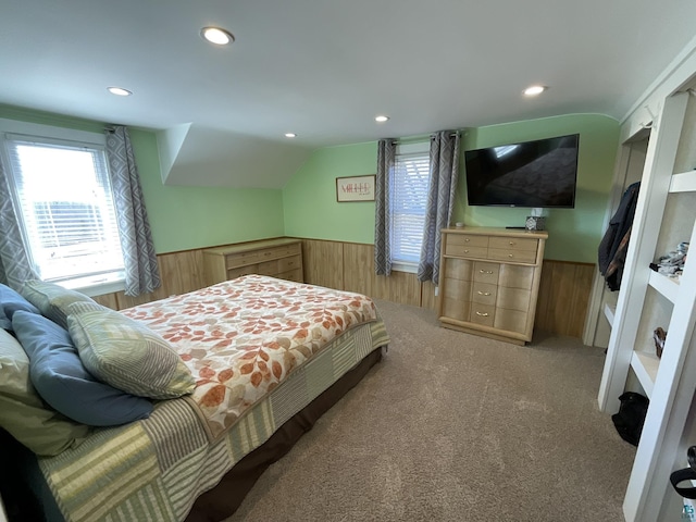 bedroom featuring a wainscoted wall, lofted ceiling, recessed lighting, wood walls, and light colored carpet