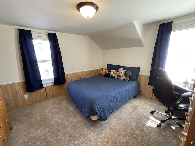 bedroom featuring a wainscoted wall, wood walls, and vaulted ceiling