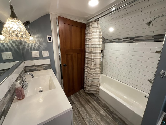 bathroom featuring shower / bath combo with shower curtain, wood finished floors, vanity, and vaulted ceiling