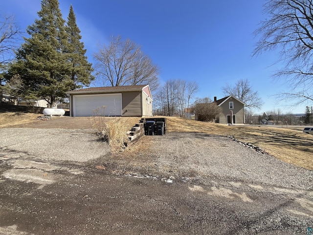 view of home's exterior with an outdoor structure and driveway