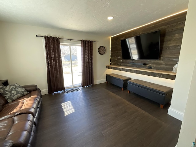 living area featuring recessed lighting, a textured ceiling, baseboards, and wood finished floors