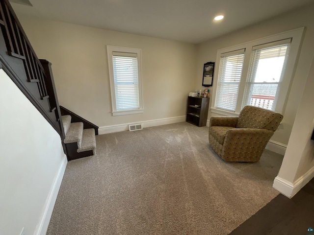 living area featuring stairs, visible vents, baseboards, and carpet flooring