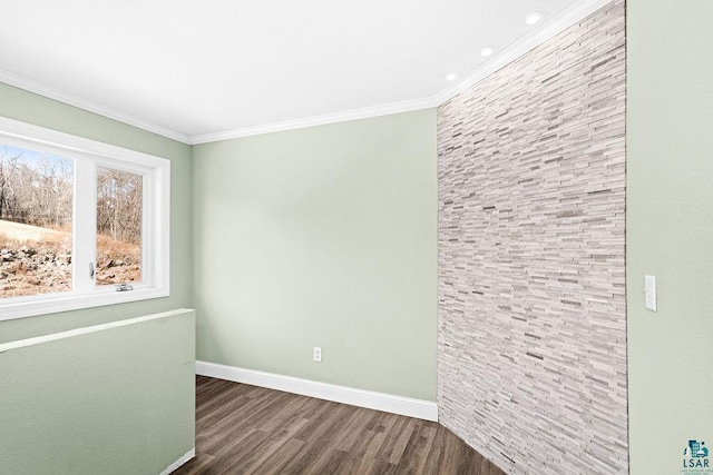 empty room featuring baseboards, wood finished floors, and ornamental molding