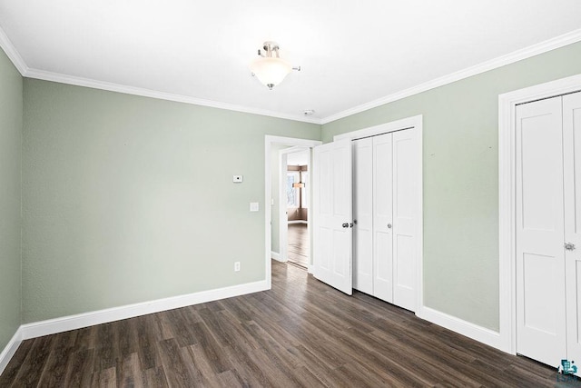 unfurnished bedroom featuring crown molding, dark wood-style floors, and baseboards