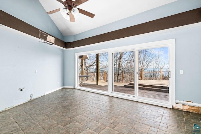 spare room with vaulted ceiling, a ceiling fan, baseboards, and stone finish flooring