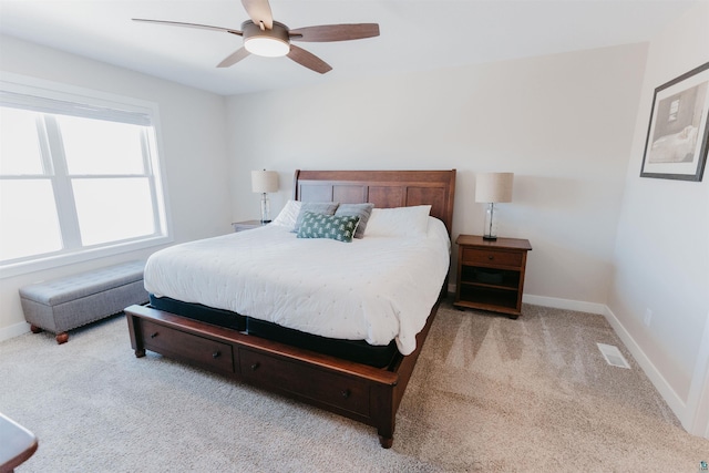 carpeted bedroom with a ceiling fan, baseboards, and visible vents