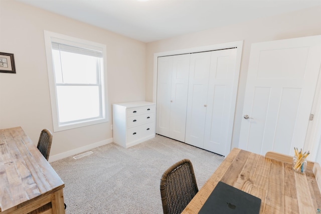 office area with visible vents, light carpet, and baseboards