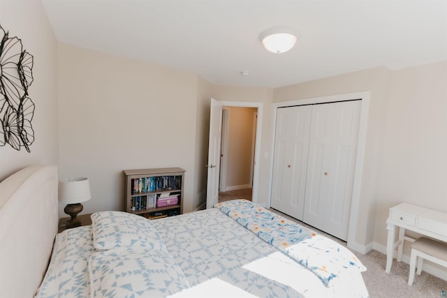 carpeted bedroom featuring baseboards and a closet