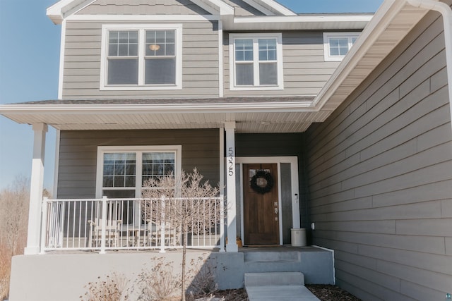 view of exterior entry featuring covered porch