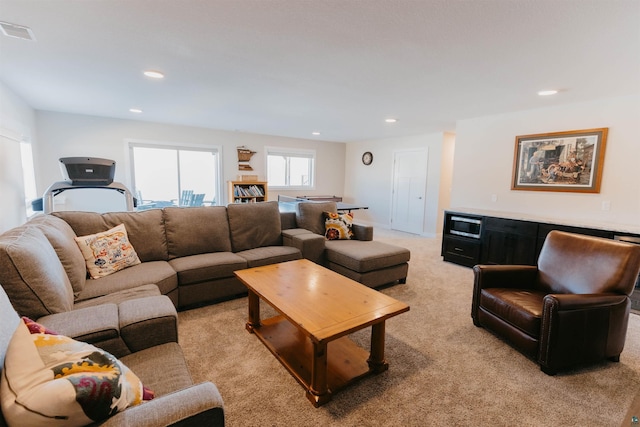 living area with recessed lighting, visible vents, and light carpet