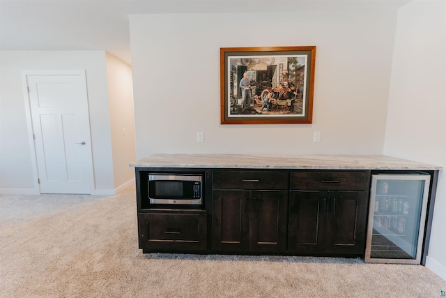 room details with wine cooler, stainless steel microwave, baseboards, and carpet