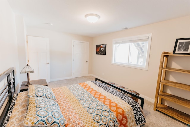 carpeted bedroom featuring visible vents and baseboards