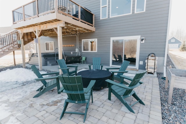 view of patio / terrace featuring stairs, a deck, and a hot tub