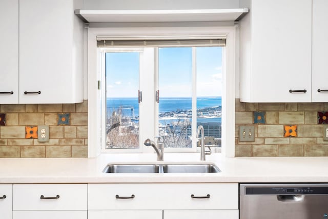 kitchen featuring dishwasher, light countertops, white cabinets, and a sink