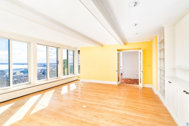 empty room featuring beamed ceiling, baseboards, ornamental molding, and light wood finished floors